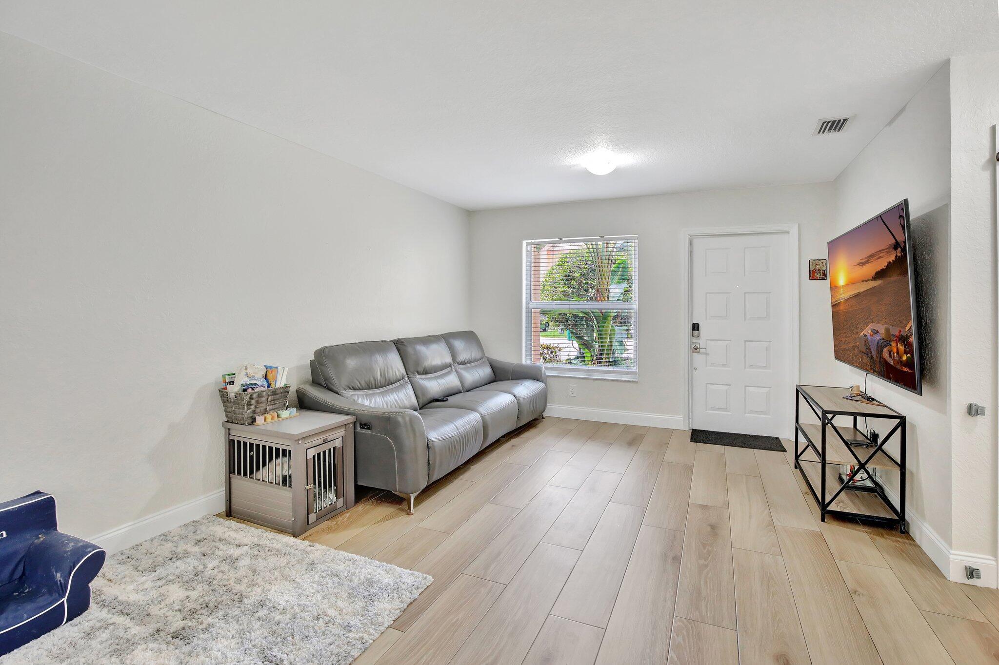 8730 Southwest 21st Street Miramar, FL 33025 - Photo 4 of 45 a living room with furniture and a flat screen tv