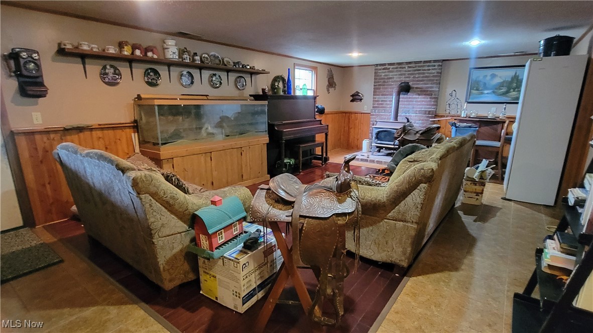 4133 Beat Road Litchfield, OH 44253 - Photo 16 of 25 Living room with a wood stove and wooden walls