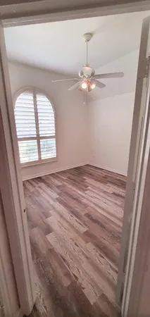 en empty room with windows and ceiling fan