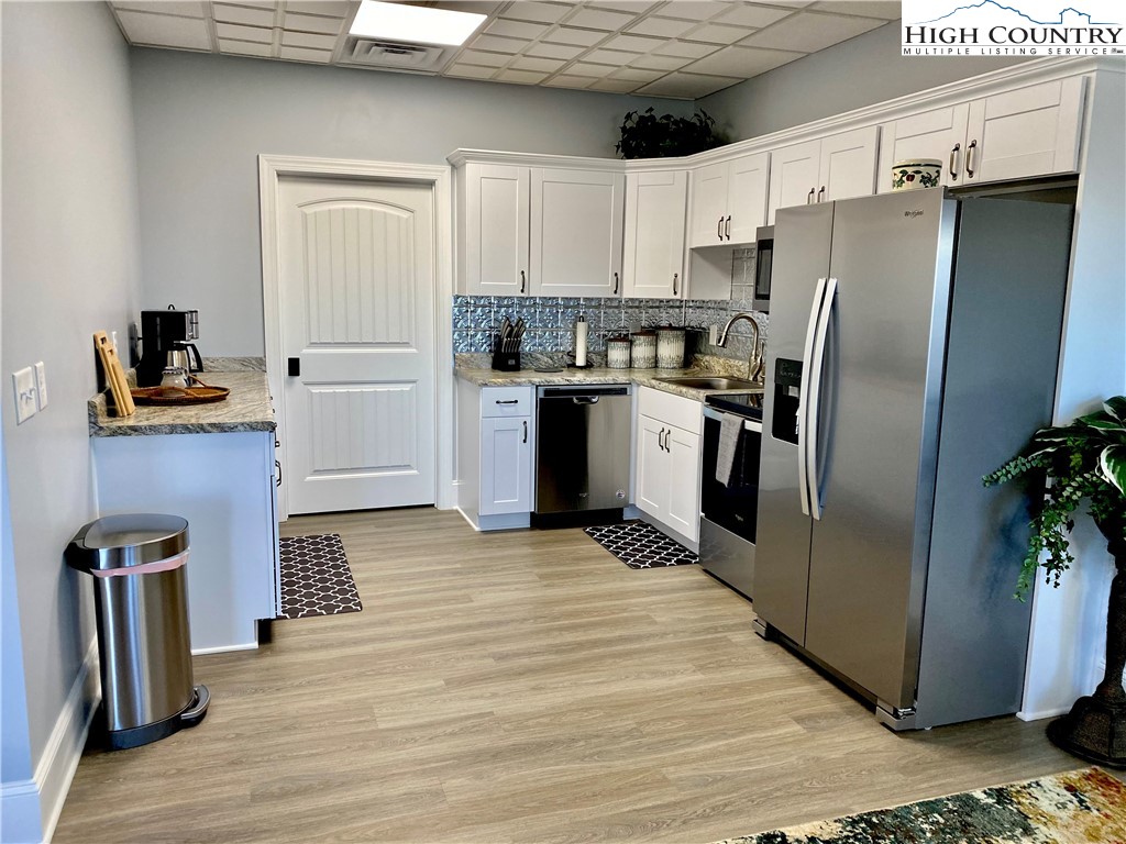 461 Chestnut Ridge Drive Jefferson, NC 28640 - Photo 37 of 47 a kitchen with stainless steel appliances granite countertop a refrigerator a stove and a sink with wooden floor