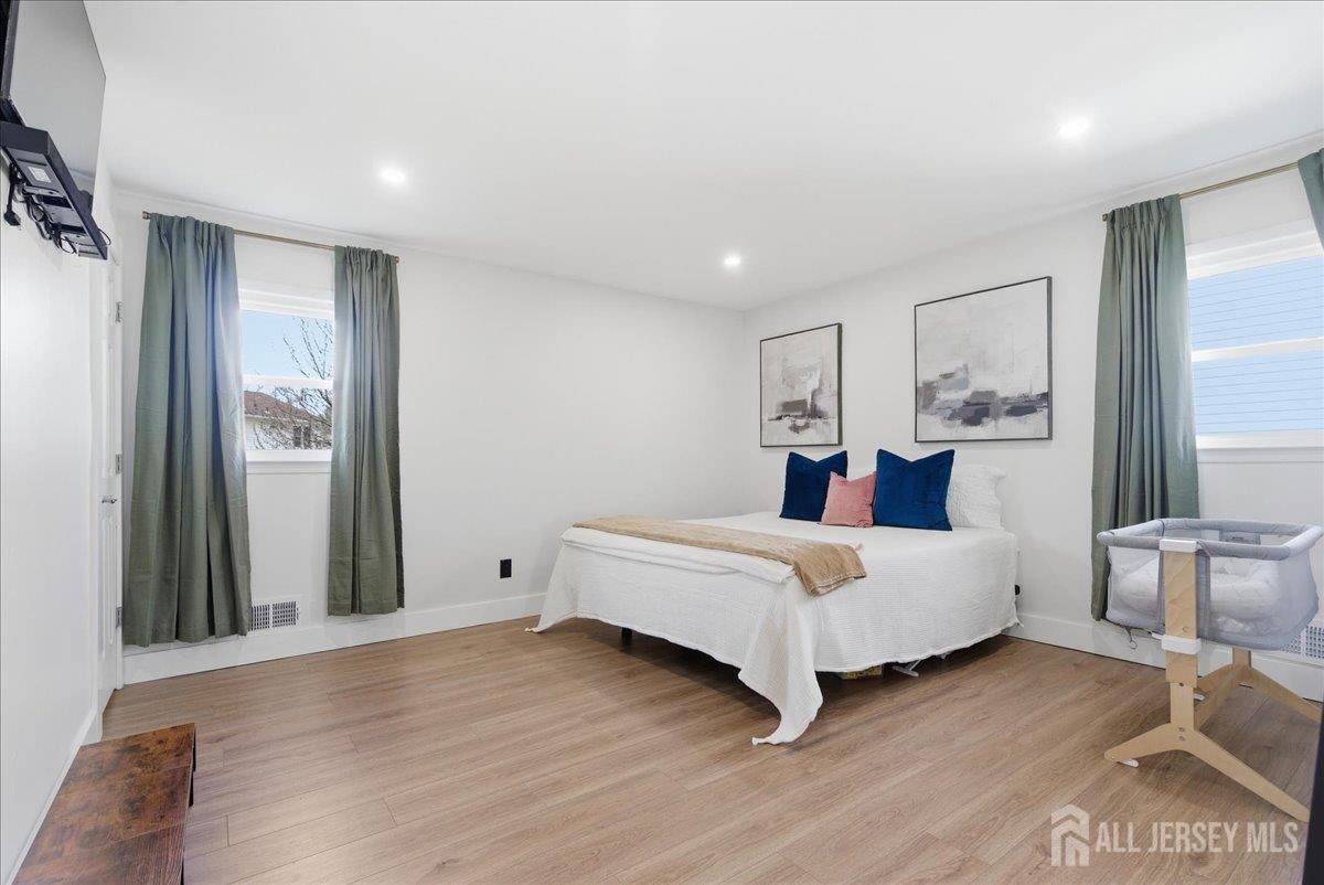 83 Garfield Avenue Colonia, NJ 07067 - Photo 16 of 45 a spacious bedroom with a bed and a large mirror