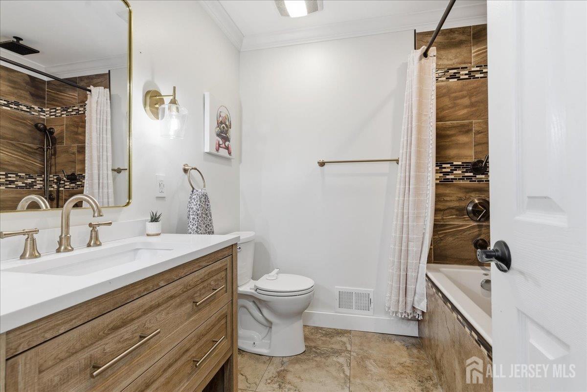 83 Garfield Avenue Colonia, NJ 07067 - Photo 17 of 45 a bathroom with a sink a toilet and shower