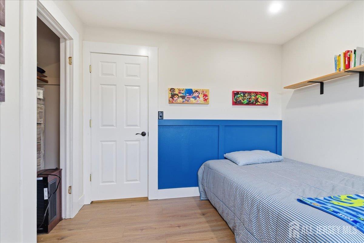83 Garfield Avenue Colonia, NJ 07067 - Photo 22 of 45 a bed room with a bed and a painting on the wall