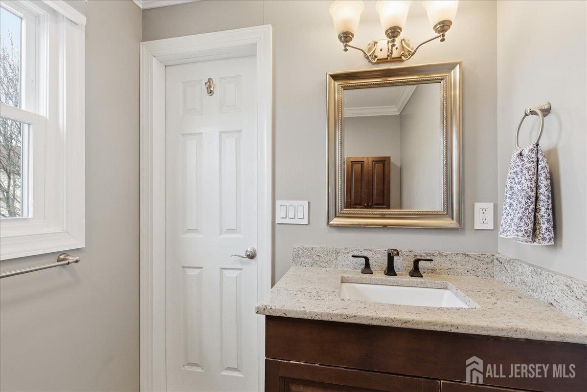 83 Garfield Avenue Colonia, NJ 07067 - Photo 23 of 45 a bathroom with a granite countertop sink and a mirror
