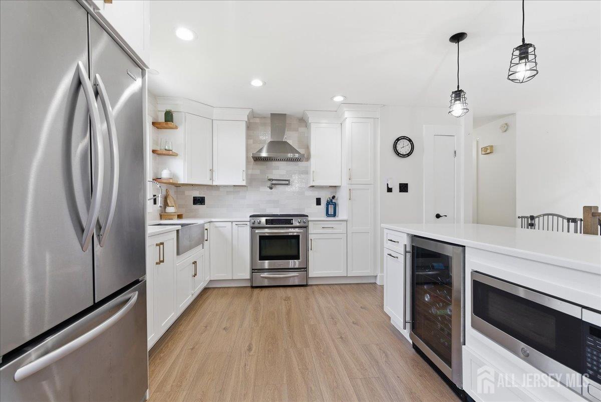 83 Garfield Avenue Colonia, NJ 07067 - Photo 4 of 45 a kitchen with white cabinets stainless steel appliances and sink