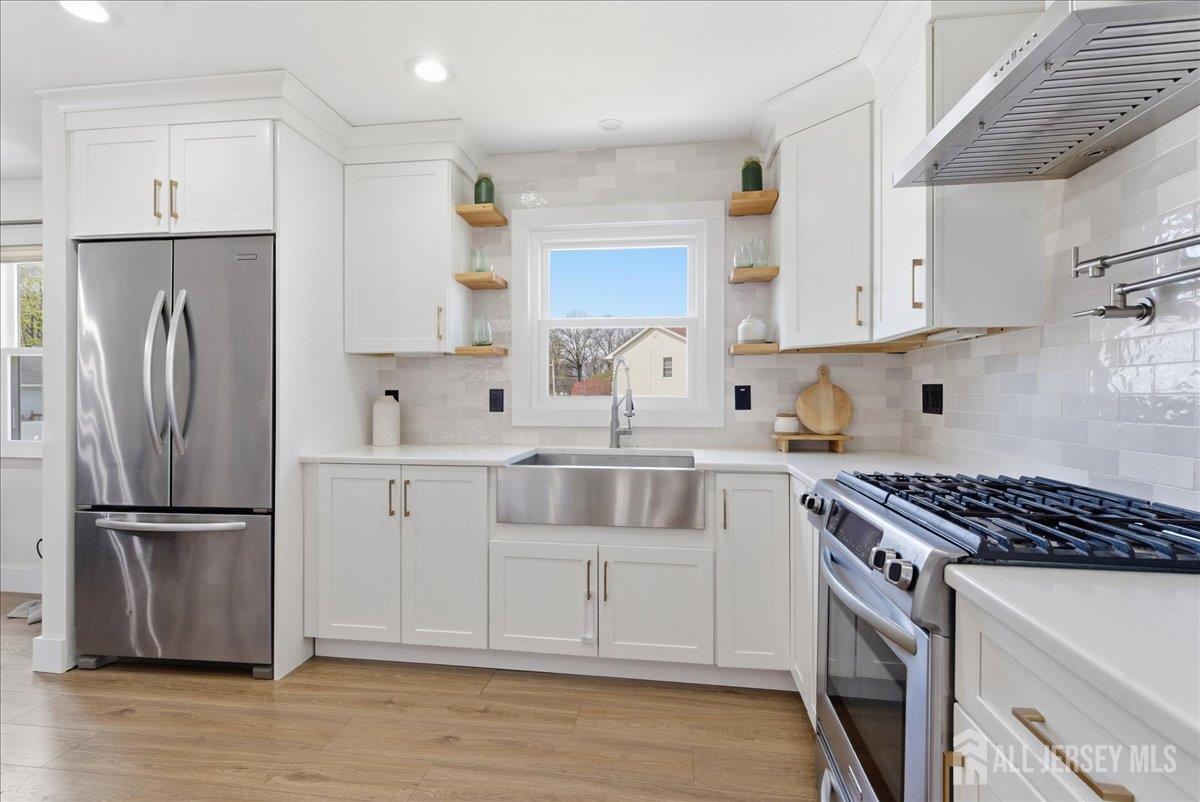 83 Garfield Avenue Colonia, NJ 07067 - Photo 6 of 45 a kitchen with white cabinets and stainless steel appliances