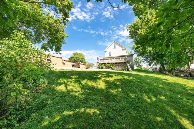 a view of a house with backyard and trees