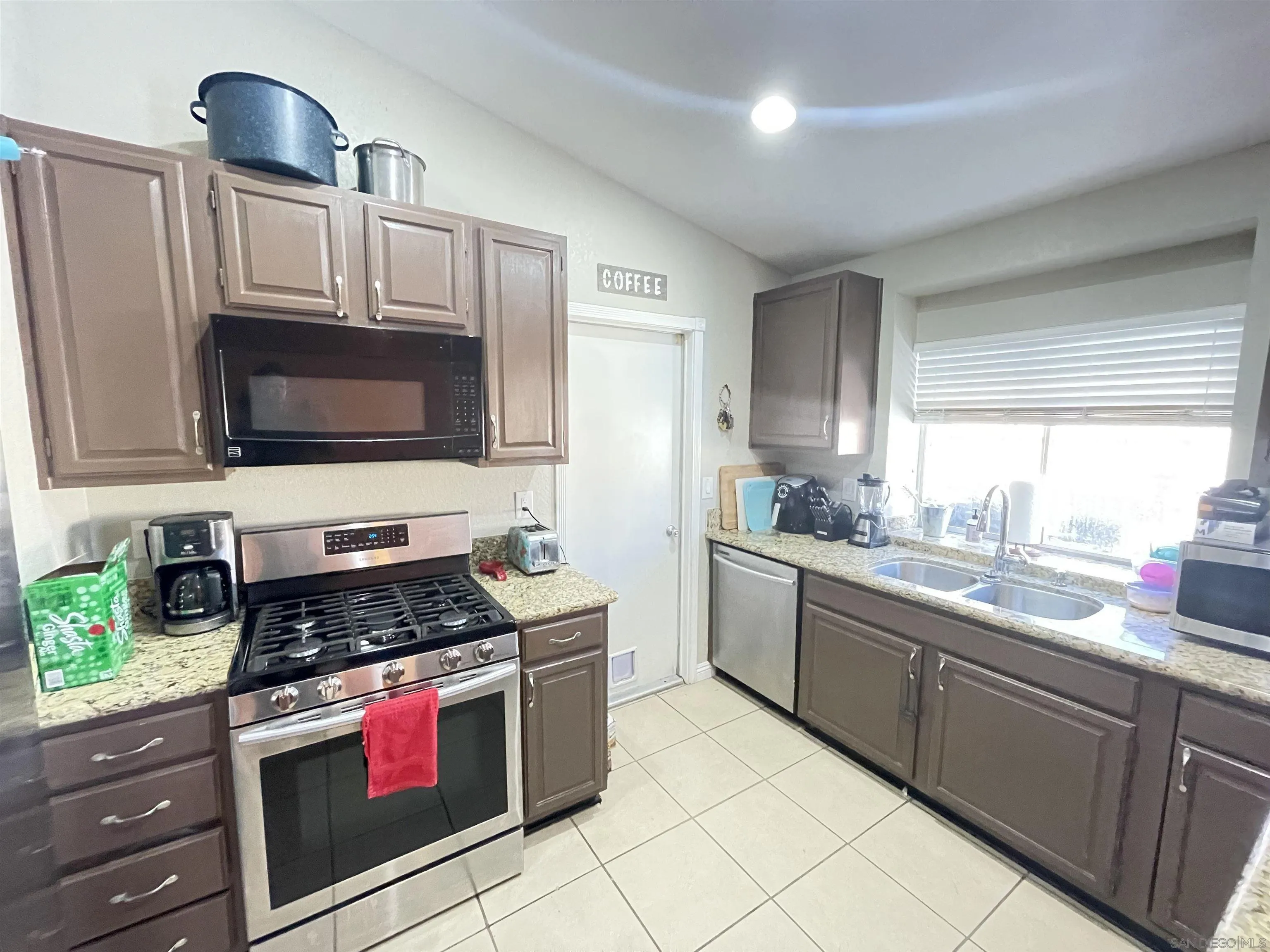 39490 Long Ridge Drive Temecula, CA 92591 - Photo 7 of 18 a kitchen with stainless steel appliances granite countertop a stove a sink and a microwave