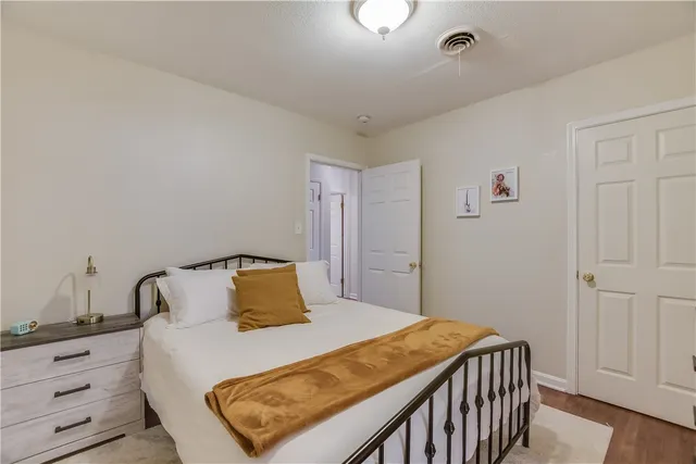 a bedroom with a bed and wooden floor