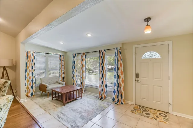 a living room with furniture and a floor to ceiling window