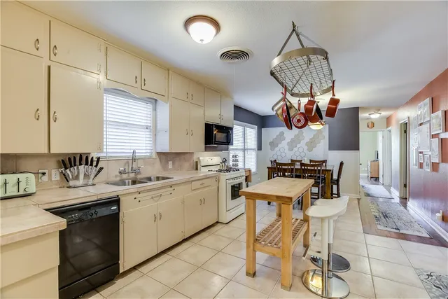 a kitchen with a sink a counter space appliances and cabinets