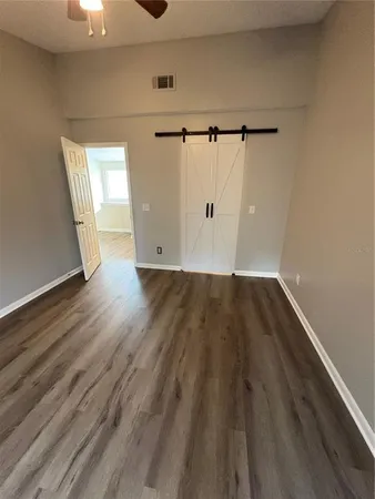 a view of an empty room with wooden floor