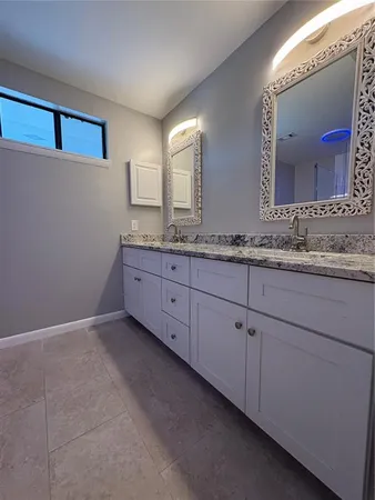 a bathroom with a double vanity sink and a mirror