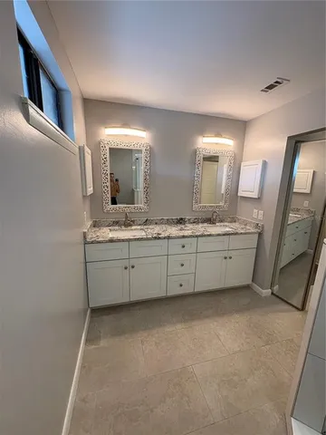 a bathroom with a double vanity sink and mirror