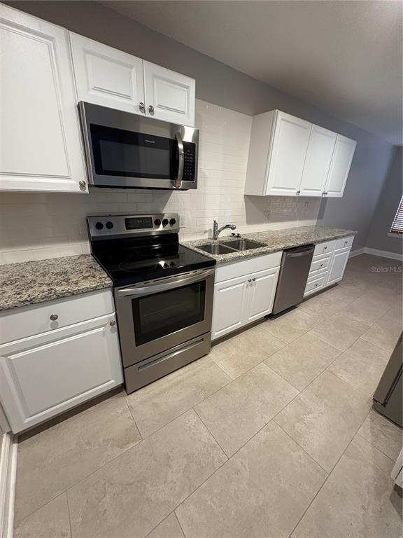 9360 Craven Road, Unit 1104 Jacksonville, FL 32257 - Photo 7 of 25 a kitchen with granite countertop a stove top oven microwave and cabinets