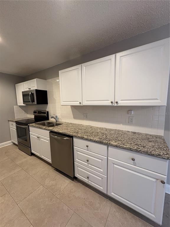 9360 Craven Road, Unit 1104 Jacksonville, FL 32257 - Photo 8 of 25 a kitchen with granite countertop white cabinets and stainless steel appliances