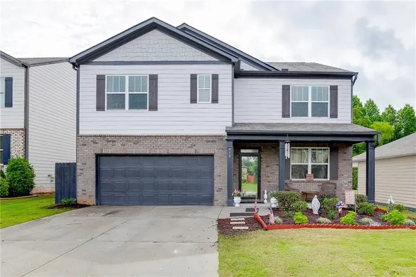 a front view of a house with a yard and garage