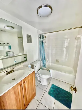 a bathroom with a sink a toilet a mirror a bathtub and shower