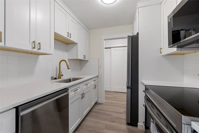 a kitchen with a sink and stainless steel appliances