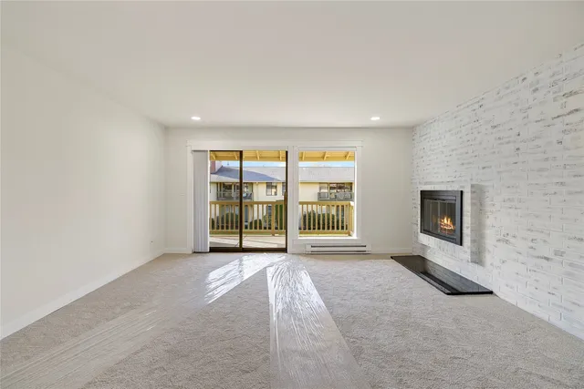 an empty room with a fireplace and windows