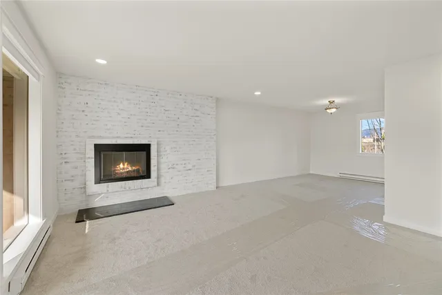 an empty room with a fireplace and a window