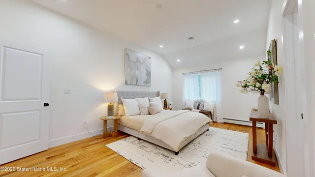 a bedroom with a bed and a potted plant