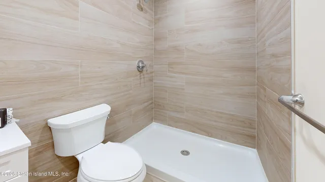a white toilet sitting next to a bath tub and a shower