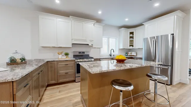 a kitchen with stainless steel appliances granite countertop a sink refrigerator and cabinets