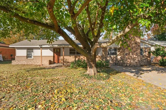 a view of a house with a tree in the yard