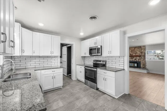 a kitchen with stainless steel appliances granite countertop a sink and a stove
