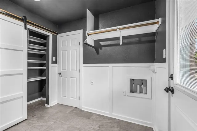 an empty room with wooden floor chandelier fan and windows