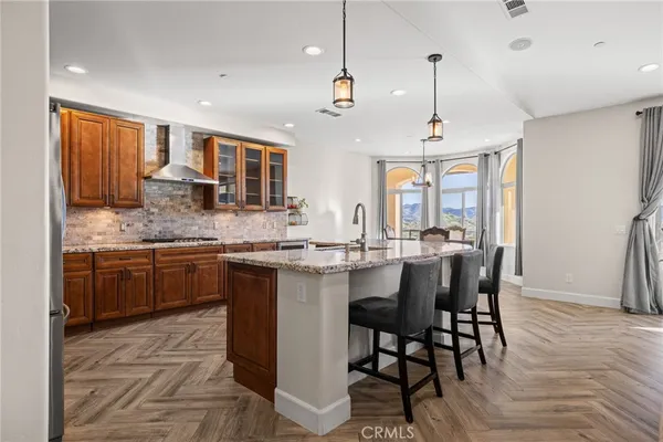 a kitchen with stainless steel appliances granite countertop wooden floor window and cabinets