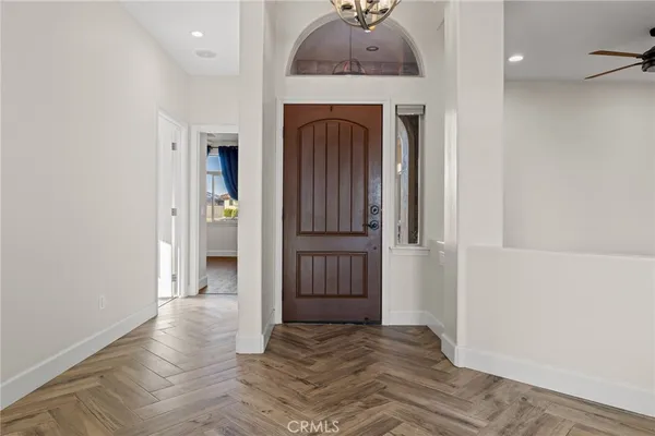 a living room with furniture kitchen view and a chandelier