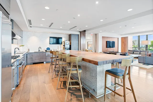 a living room with furniture kitchen view and a large window