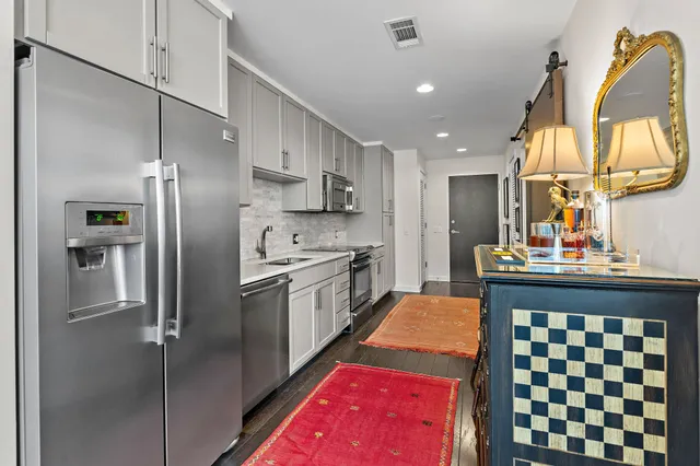 a kitchen with white cabinets and stainless steel appliances