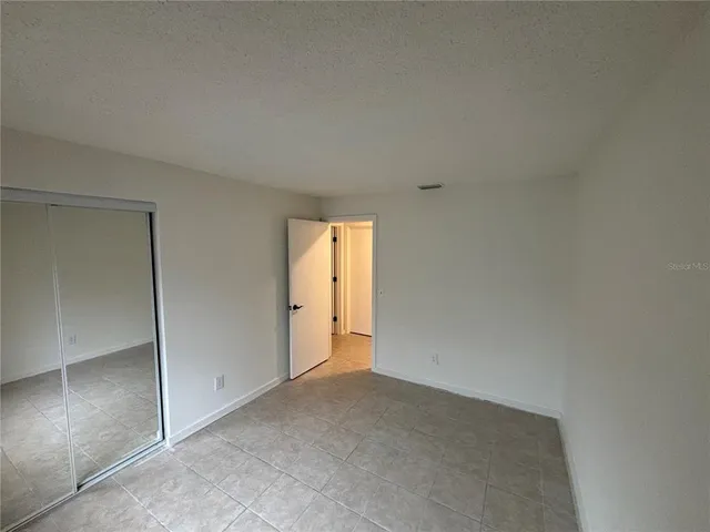 an empty room with windows and closet