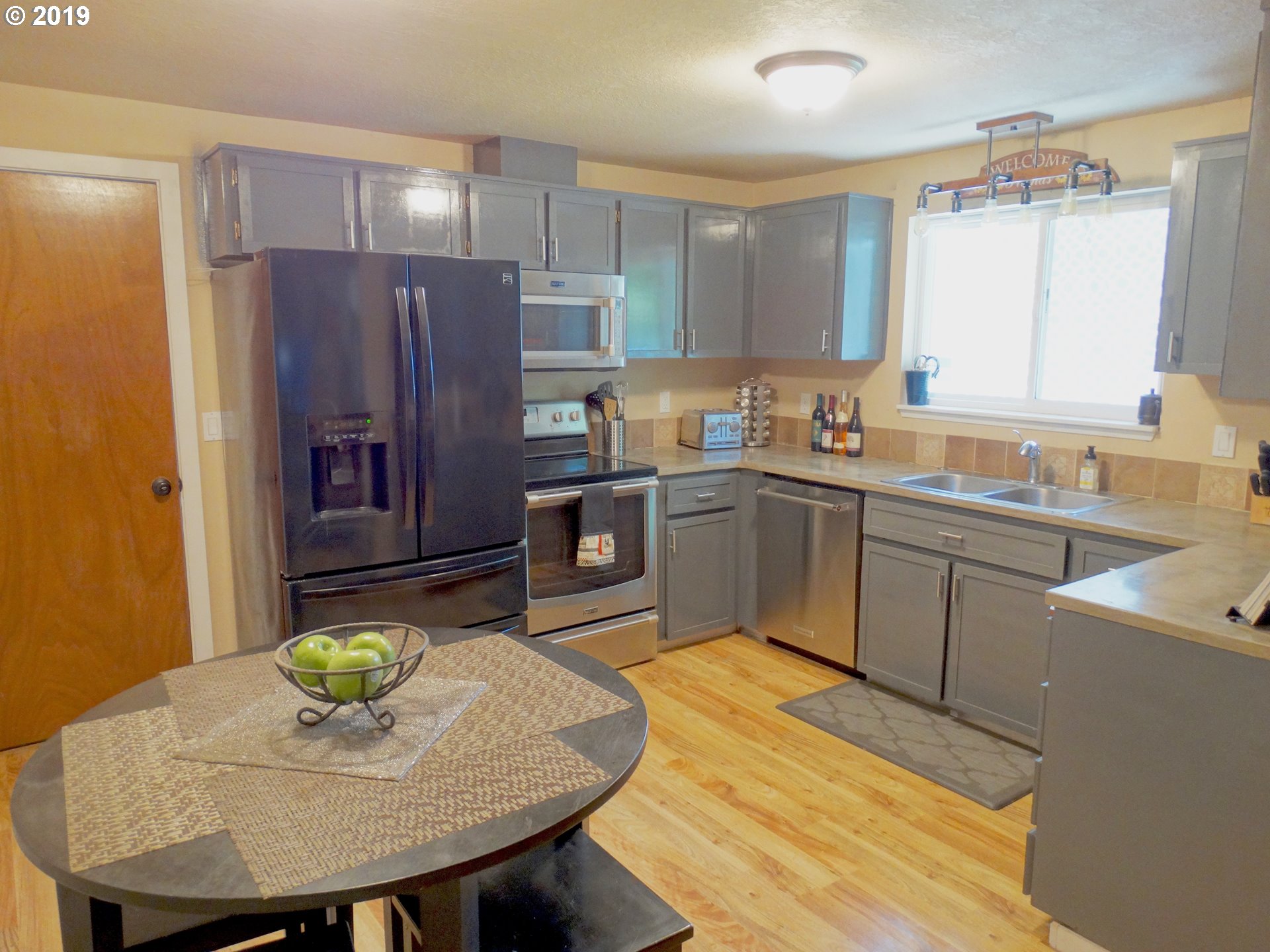 4100 Southwest Dilley Road Forest Grove, OR 97116 - Photo 6 of 27 a kitchen with cabinets a sink stainless steel appliances and dining table