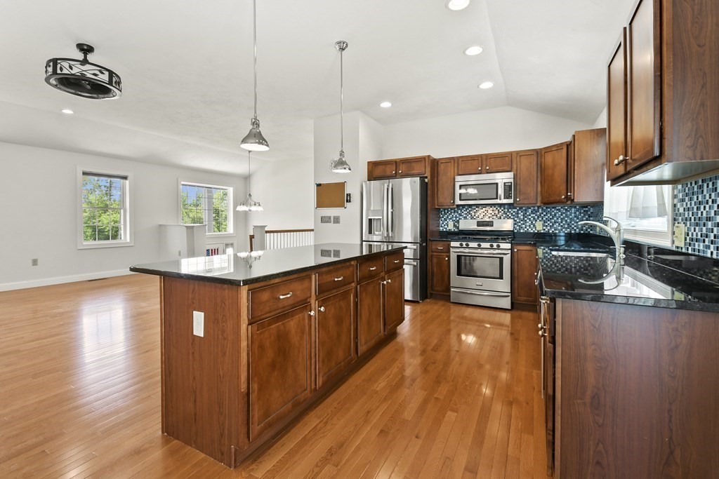 8 Hickory Way Ayer, MA 01432 - Photo 12 of 35 a kitchen with stainless steel appliances granite countertop wooden cabinets a stove top oven a sink and dishwasher
