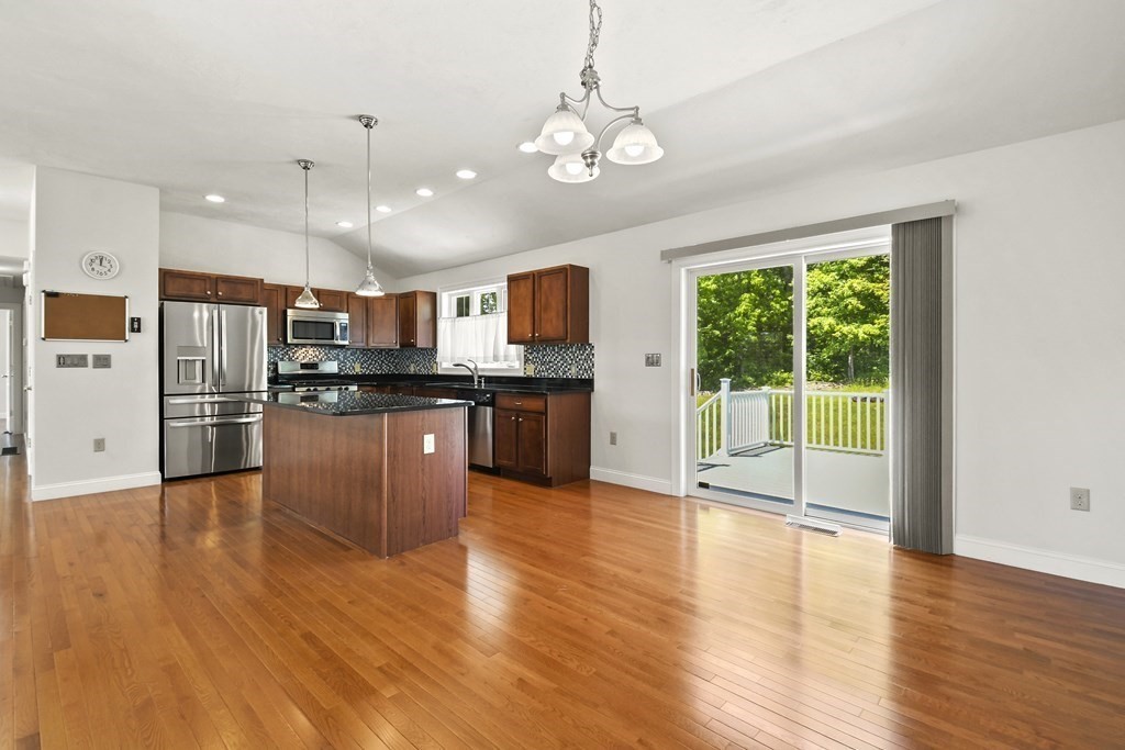 8 Hickory Way Ayer, MA 01432 - Photo 14 of 35 a view of kitchen with stainless steel appliances granite countertop a stove top oven a refrigerator with island and wooden floor