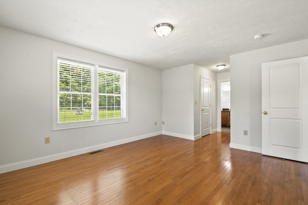 8 Hickory Way Ayer, MA 01432 - Photo 18 of 35 a view of an empty room with wooden floor and a window