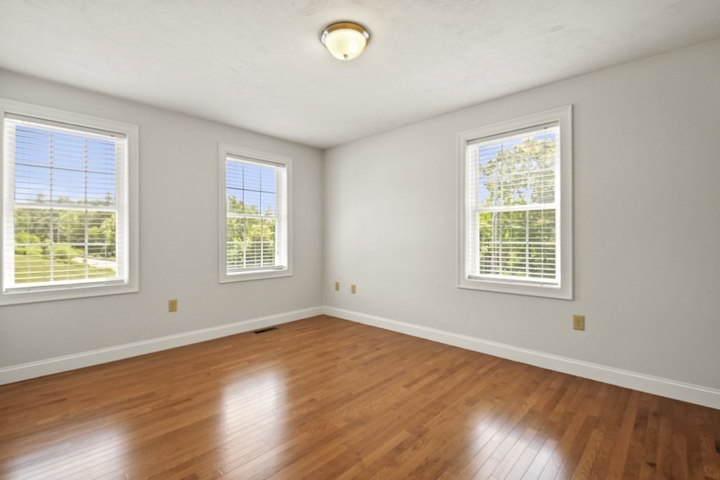 8 Hickory Way Ayer, MA 01432 - Photo 20 of 35 a view of an empty room with wooden floor and a window