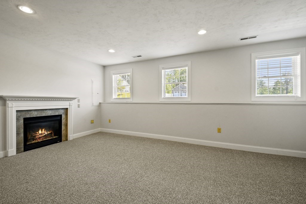 8 Hickory Way Ayer, MA 01432 - Photo 23 of 35 an empty room with windows and fireplace