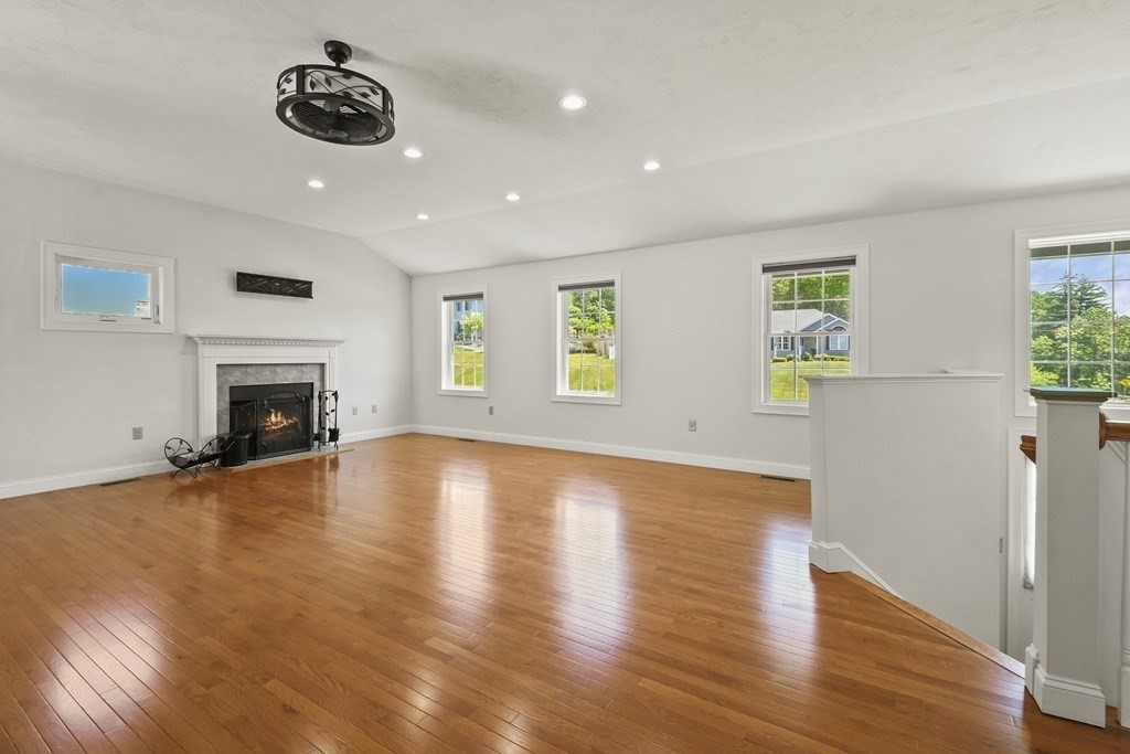 8 Hickory Way Ayer, MA 01432 - Photo 6 of 35 a view of an empty room with wooden floor and a fireplace