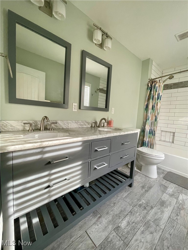 1544 Edgefield Road Lyndhurst, OH 44124 - Photo 33 of 36 Bathroom featuring shower / bath combo with shower curtain, double vanity, and wood finish floors