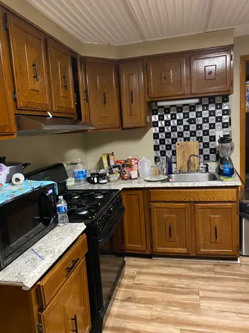 a kitchen with granite countertop a sink dishwasher stove and cabinets
