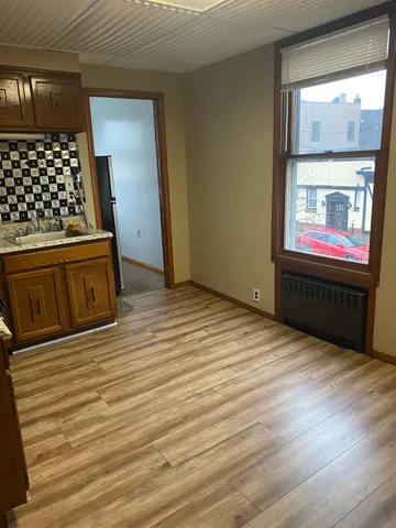 an empty room with wooden floor and cabinet