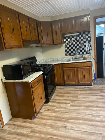 a kitchen with wooden cabinets and a stove top oven