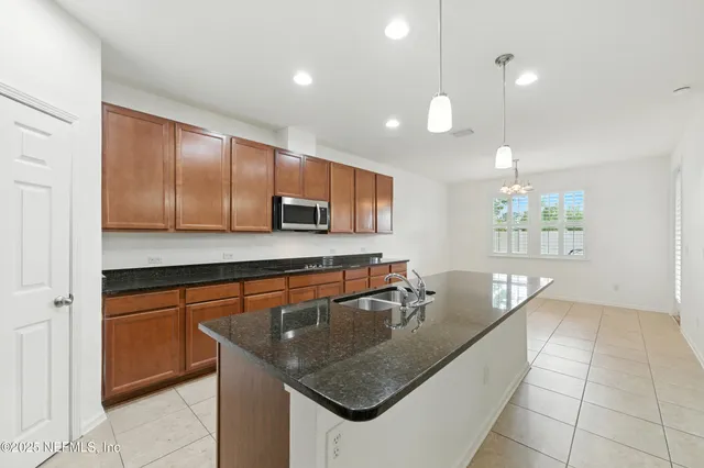 a kitchen with stainless steel appliances granite countertop a sink a counter space and cabinets