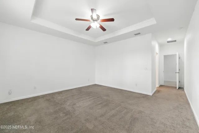 an empty room with ceiling fan and window