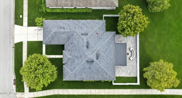 a aerial view of a house with a yard and large tree